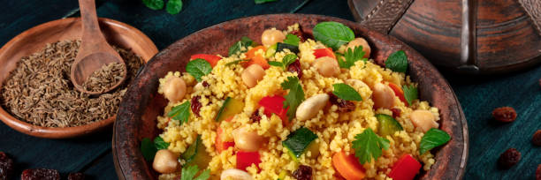 istock Couscous panorama. Kuskus with vegetables, herbs, spices, almonds, raisins 1296090054