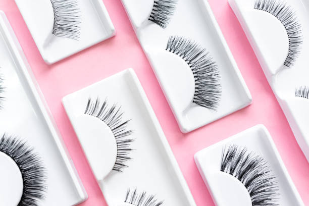 istock Different fake eyelashes on a trendy pastel pink background. Beauty pop art pattern. Makeup accessories. Cosmetics products for women. Bright colorful backdrop. Close up. Flat lay. Top view 1296091917