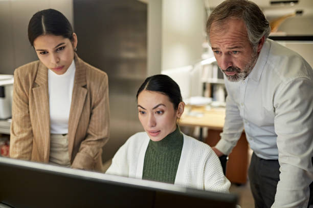 istock Coworkers Looking at Computer Monitor with Surprise 1296093728
