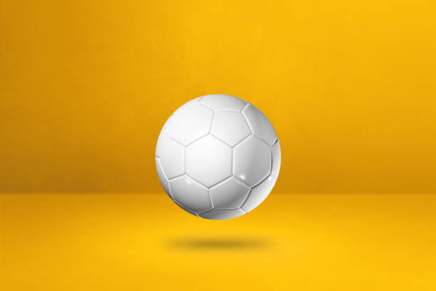 istock White soccer ball on a yellow studio background 1296094921