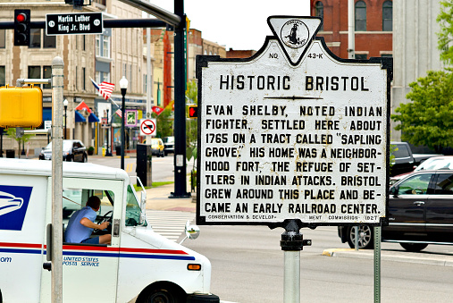 Bristol, Virginia and Bristol, Tennessee / USA - July 19, 2018: A U.S. Postal Service van turns past a historic marker in the twin cities of Bristol, Tennessee (l), and Bristol, Virginia (r).