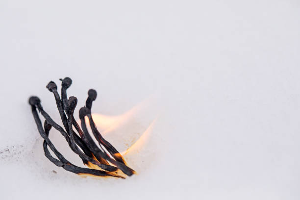 Several matches burn out in the snow.