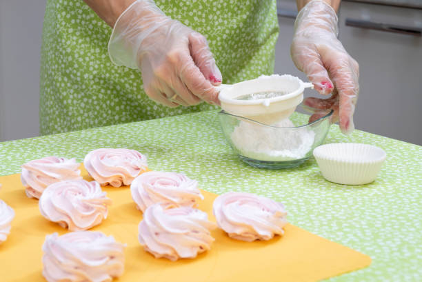 istock The pastry chef collects powdered sugar in a sieve before sprinkling fresh cooked marshmallows. 1296105123
