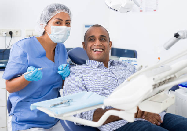 istock Man sitting in dental chair after teeth cure 1296105337