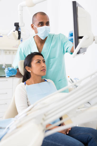 istock Doctor man dentist shows patient x-ray 1296105363