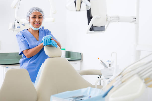 Successful professional woman dentist standing in dental office Portrait of successful professional woman dentist standing in blue uniform in modern medical dental office dental hygienist stock pictures, royalty-free photos & images