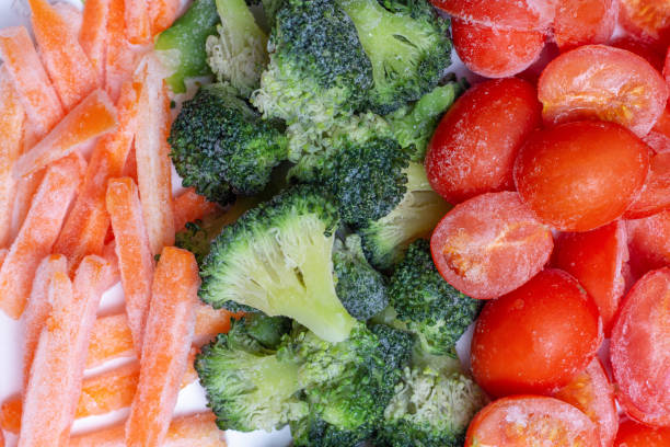 istock Frozen tomatoes, carrots and broccoli close-up, top view 1296105544