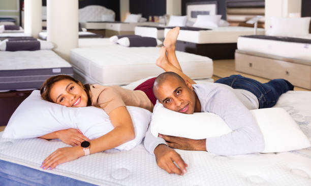 istock Glad couple testing softness of mattress 1296105630