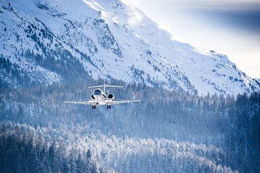 Business Jet approaching in front of snow covered mountains