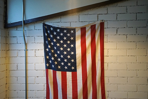 Hanging United States flag on white wall