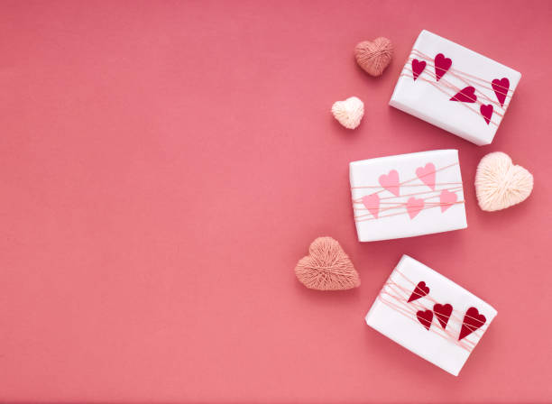 istock Gift boxes on pink background with wrapped paper hearts 1296108854