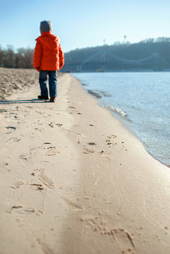 one person walking on an empty beach.
