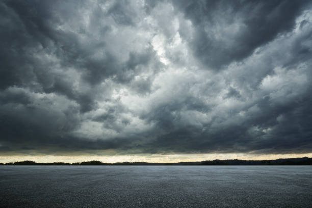 piso térreo de asfalto vazio com dramáticas nuvens de vento céu . - céu dramático - fotografias e filmes do acervo