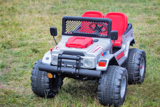 On the lawn stands double baby car for children on a wide steady wheel.