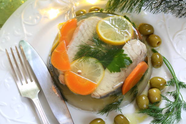 Jellied sturgeon with lemon Jellied sturgeon with lemon, olives and glasses of white wine aspic stock pictures, royalty-free photos & images