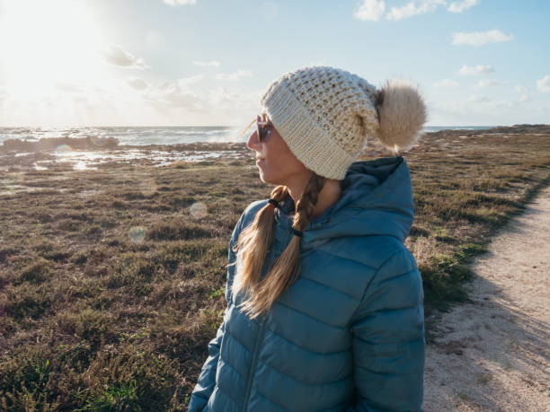 istock Woman contemplates coastline at sunset 1296112504