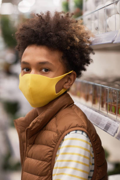 istock African-American Boy Wearing Mask in Store 1296112767