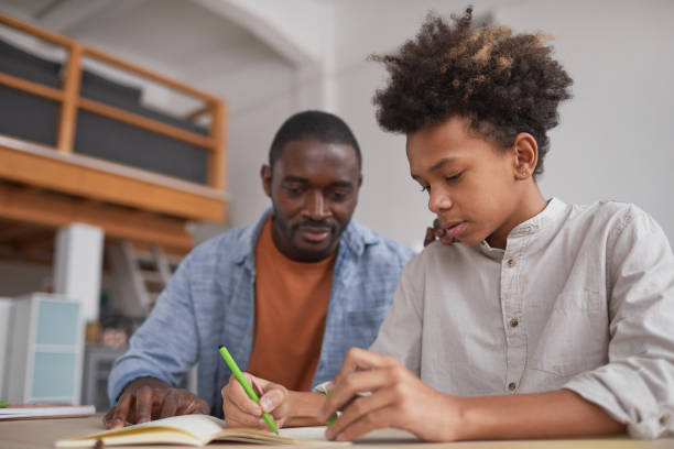 istock African-American Boy doing Homework with Dad 1296112797
