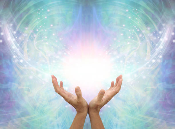 Connecting to High Resonance Healing Energy female cupped hands reaching up into a beautiful white light and green blue  energy field background with shimmering sparkles and white light flowing outwards quantum photos stock pictures, royalty-free photos & images