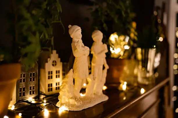 Photo of white figurines of children singing Christmas songs on the piano. New Year