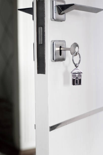 istock Home key with metal house keychain in keyhole 1296114865