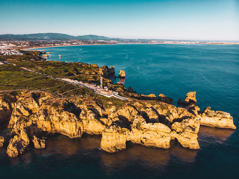 Amazing Drone Shot of Beautiful Ponta da Piedade with the Farol da Ponta da Piedade and Lagos in the back, Portugal
