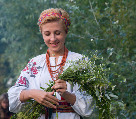 Kiev, Kievskaya Oblast/Ukraine - 07.06.2011. Woman dressed in Ukraine traditional clothes makes wreath