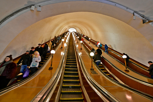 Russia, Moscow 12/29/2019. The Moscow metro is one of the largest and most beautiful in the world.Moscow Metro, escalator with people, station, Various frescoes and drawings decorating the walls of the metro.