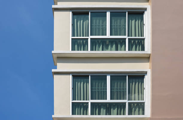 istock Modern building against a clear blue sky. Two glass windows with curtain. 1296119772