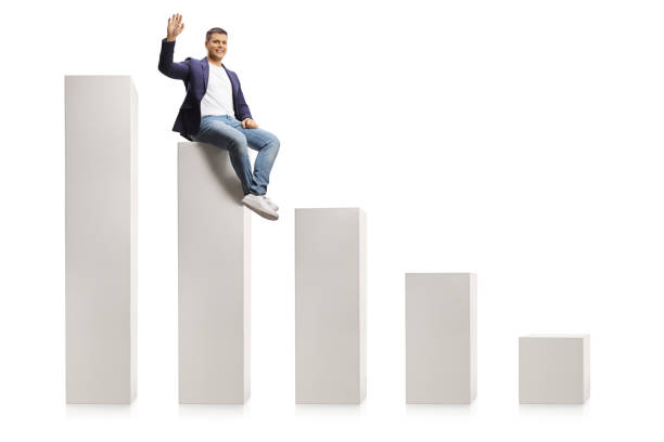 istock Man in jeans and suit sitting on a bar graph and waving at camera 1296121492