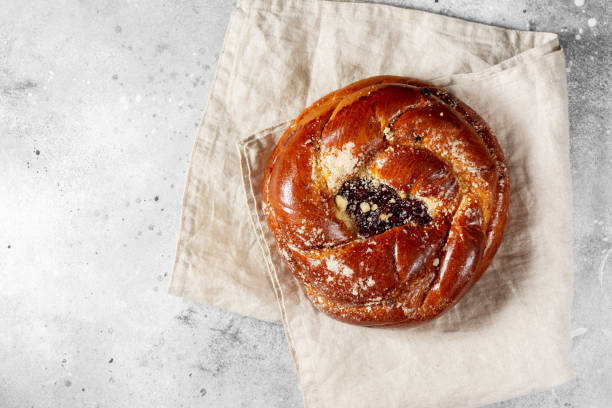 istock Buns with jam on the light gray kitchen table. Pie with cherry jam and marzipan. Delicious pastries 1296123486