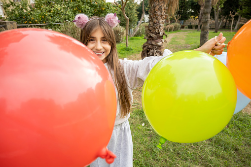 Little girl enjoyment with ballons at park