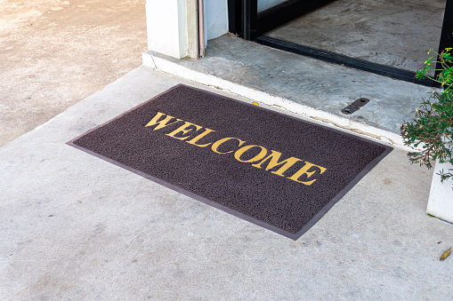 Welcome mat in shop front of door.