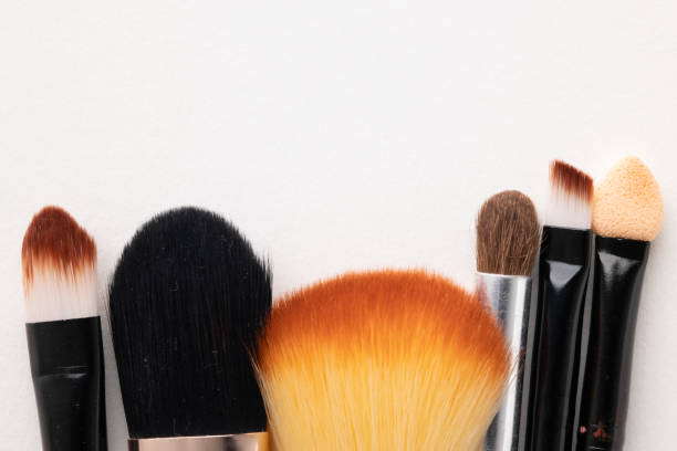 istock Top view cosmetics makeup for female on the white table background with Different brush types. 1296134698