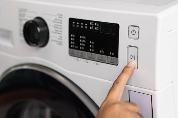 istock Finger press the switch to make the washing machine work. Home appliances 1296134777