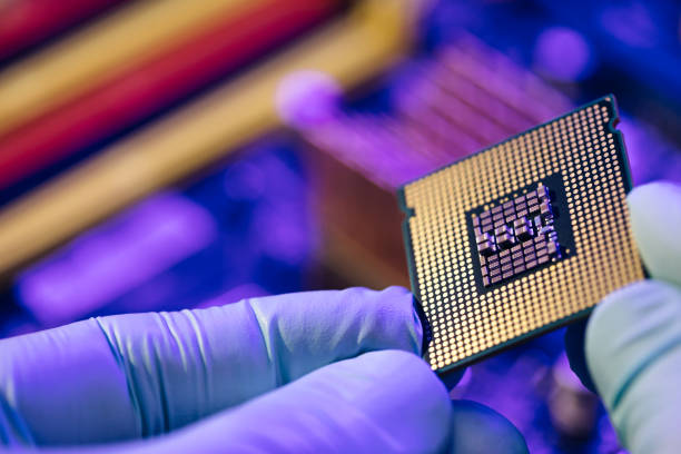 ingegnere del supporto informatico che installa il processore. microprocessore con nucleo di silicio chiaramente visibile e chip cache. installazione del processore del computer nel socket - microelectronic foto e immagini stock