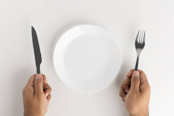 istock A man with a knife and fork to eat on the plate 1296136150