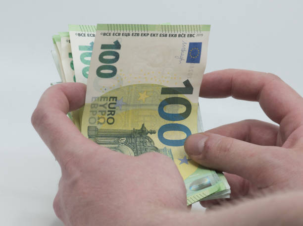 istock holding one hundred euro bills in hand 1296136417