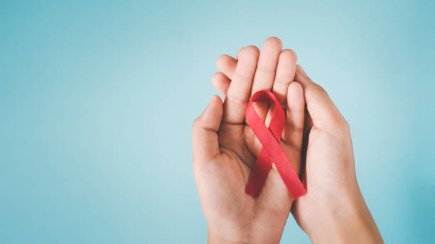 czerwona wstążka na rękach człowieka z grunge niebieskim tłem dla koncepcji świadomości hiv, światowy dzień aids, światowy dzień nadciśnienia tętniczego, światowy dzień walki z rakiem - world aids day zdjęcia i obrazy z banku zdjęć