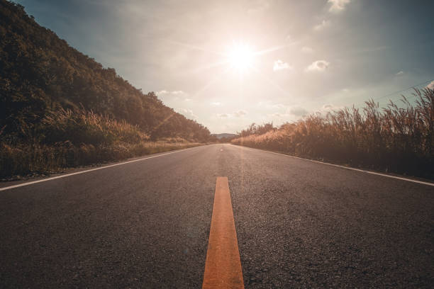 istock Empty asphalt road through the green field 1296137733