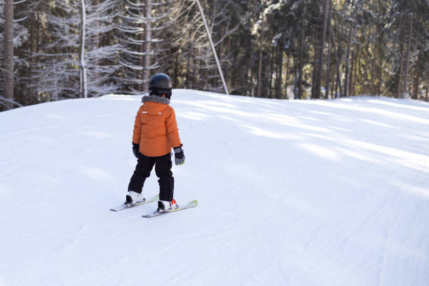 istock A boy in equipment is skiing on a snowy slope. 1296141082