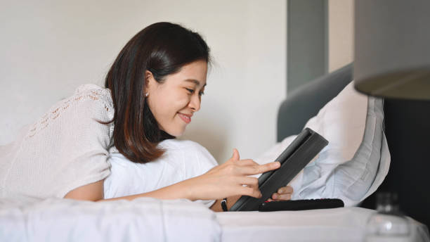 istock Young asian woman using smart phone enjoy social network and online learning at home 1296143407