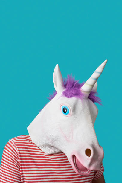 istock man wearing a unicorn mask on a blue background 1296143670