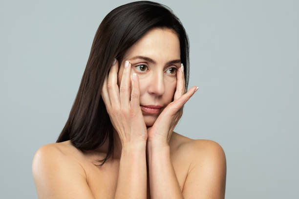 istock Beautiful middle aged woman on gray background 1296144628