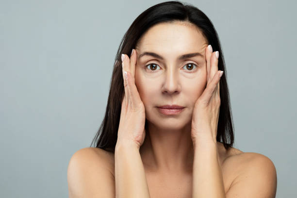 istock Beautiful middle aged woman on gray background 1296144651