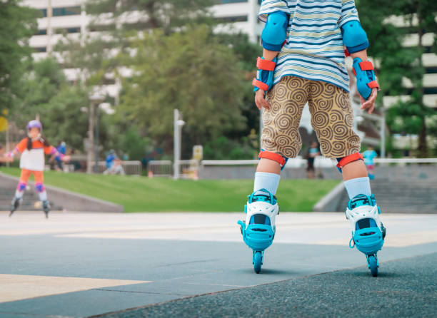 Rollerblade boy leg wearing full protection is skating in skate park with copy space. stock photo