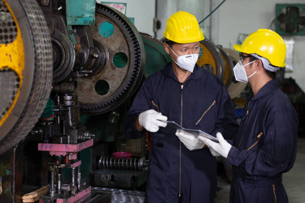 istock male engineer man or factory worker wearing face mask for protect virus, talking and using tablet about project 1296147139