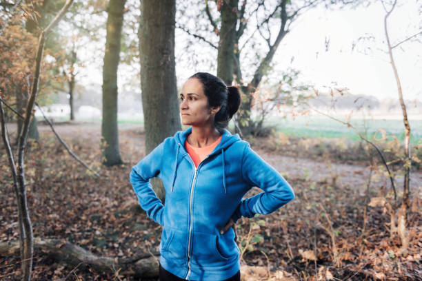 istock sportswoman standing in the woods 1296149321