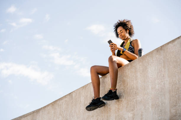 istock Athlete woman using her mobile phone outdoors. 1296149721