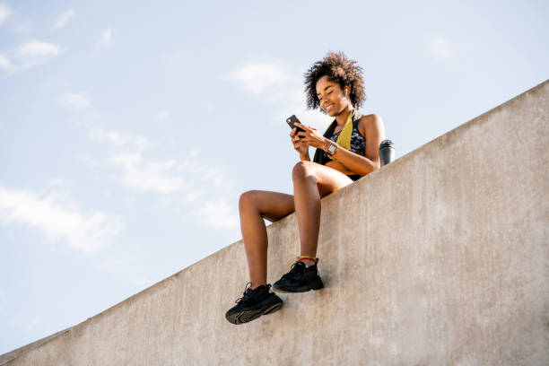 istock Athlete woman using her mobile phone outdoors. 1296149727